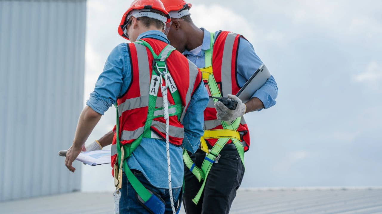 A John Peters crew on a roof, harnessed in