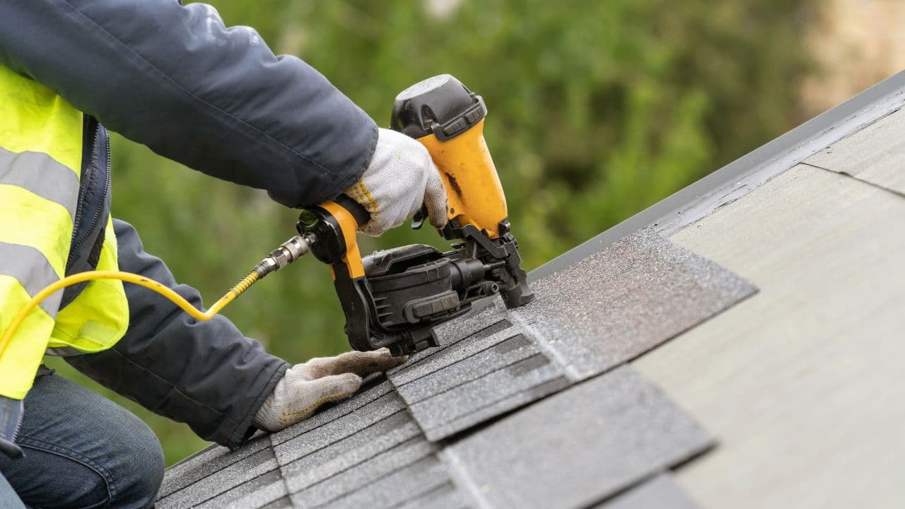 A John Peters roofer nailing architectural shingles