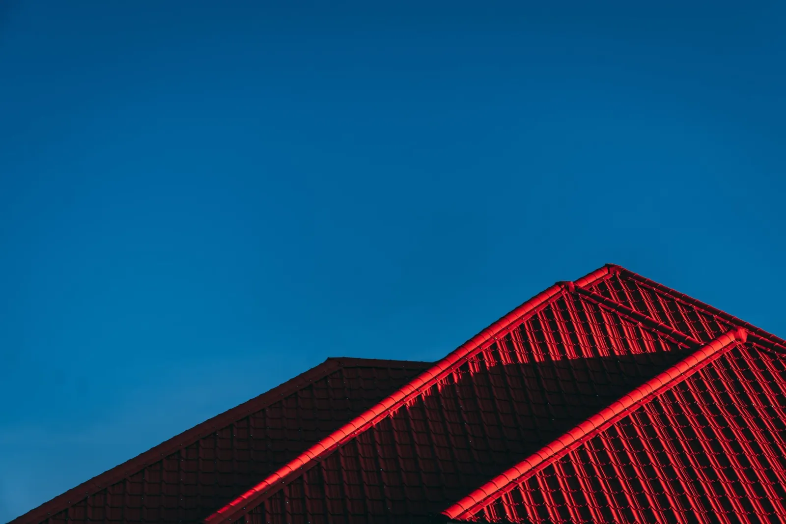 A red metal roof against a blue sky