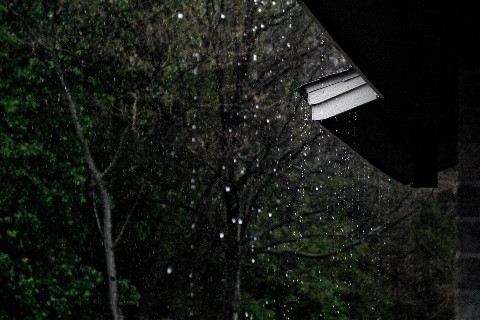 Rain pouring off a roof edge into a gutter